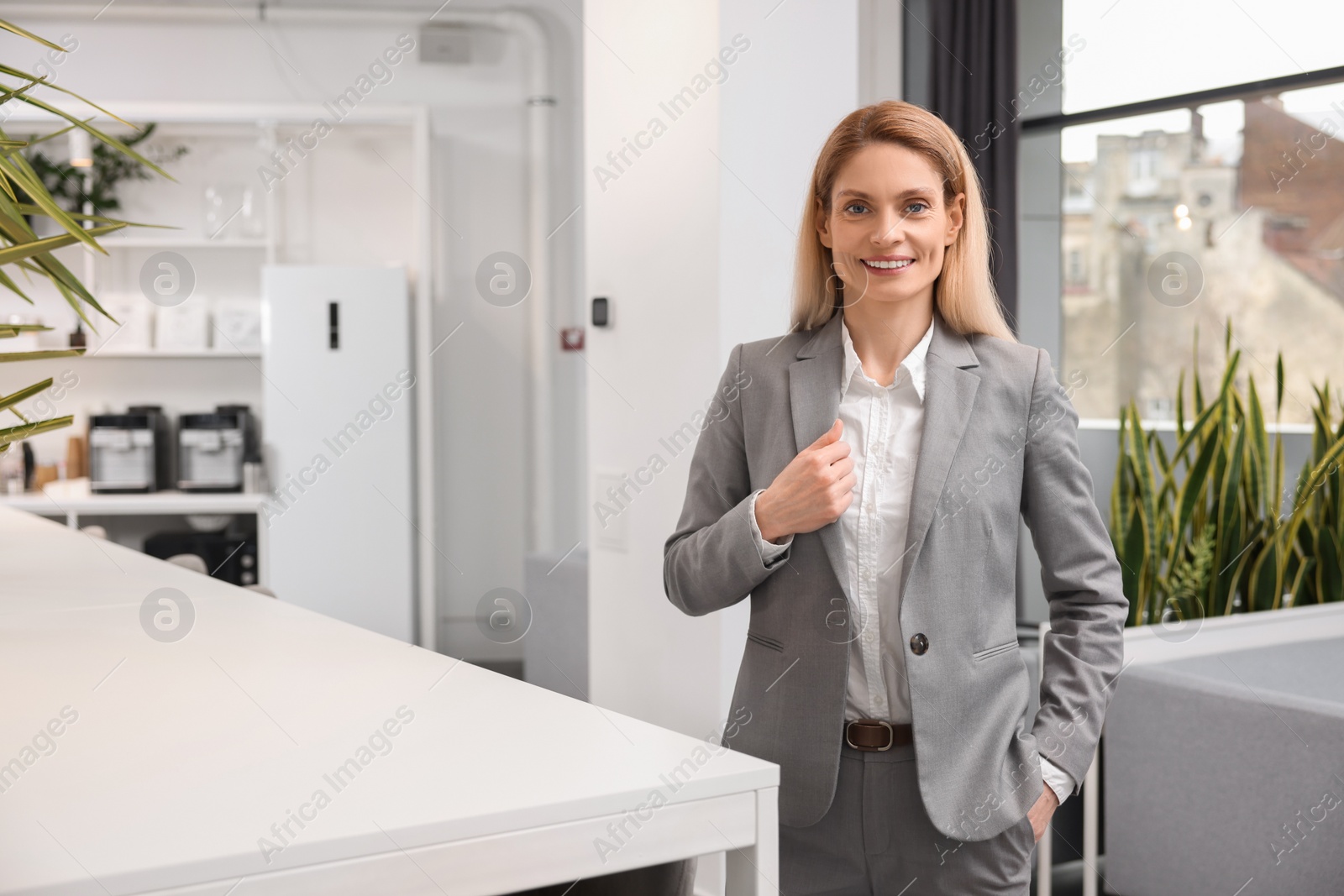 Photo of Female real estate agent indoors. Space for text