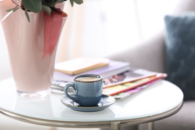 Photo of Cup of coffee and magazines on table