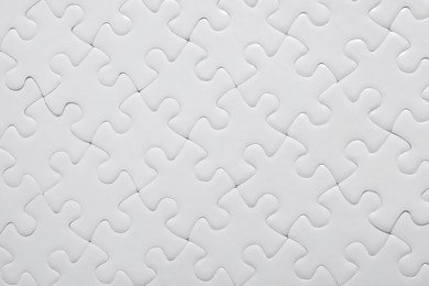 Blank white puzzle as background, top view