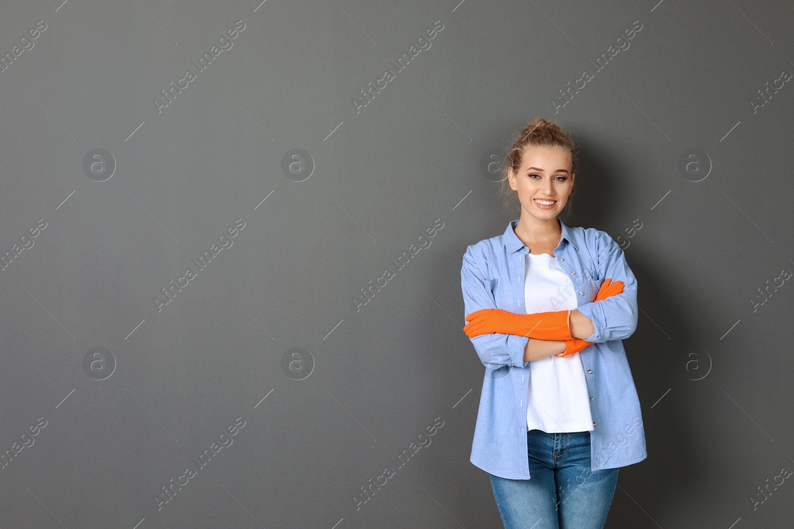 Photo of Woman in gloves on grey background. Cleaning service