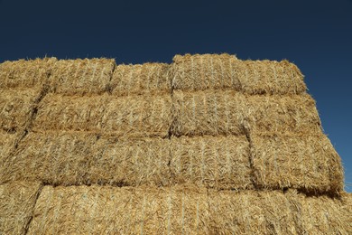 Many hay bales against blue sky, low angle view