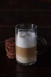 Photo of Cup of aromatic latte macchiato and chocolate cookies on wooden table