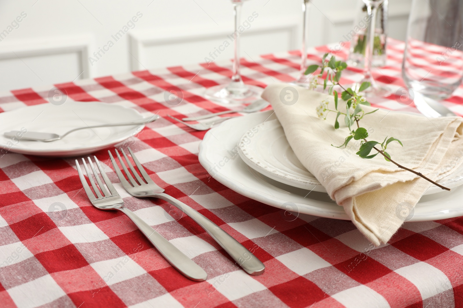 Photo of Stylish setting with cutlery, plates, napkin and floral decor on table