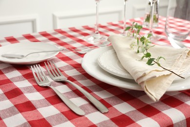 Photo of Stylish setting with cutlery, plates, napkin and floral decor on table