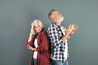 Mature couple having argument on color background. Relationship problems