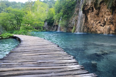 Photo of Wooden bridge over lake and beautiful view of waterfall