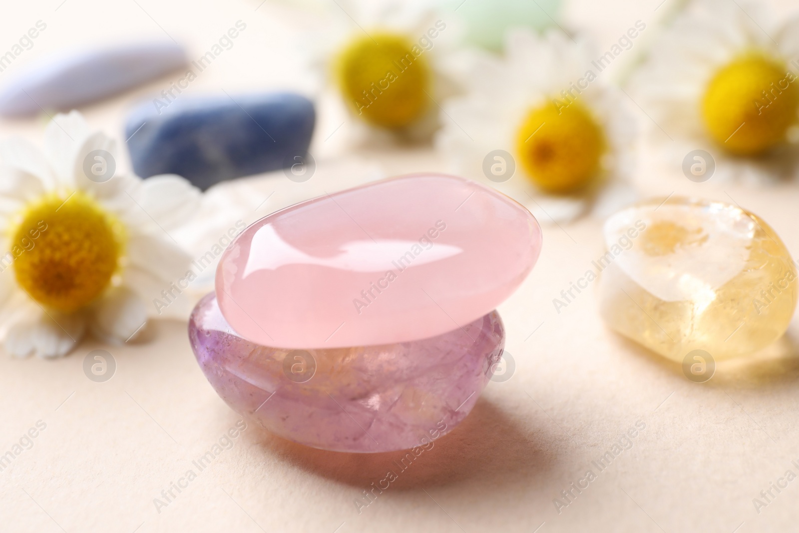 Photo of Beautiful gemstones on beige table, closeup. Healing crystals