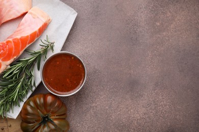 Photo of Tasty fish marinade and products on brown textured table, flat lay. Space for text