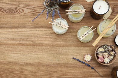 Glass jars with wax and space for text on wooden table, flat lay. Handmade candle