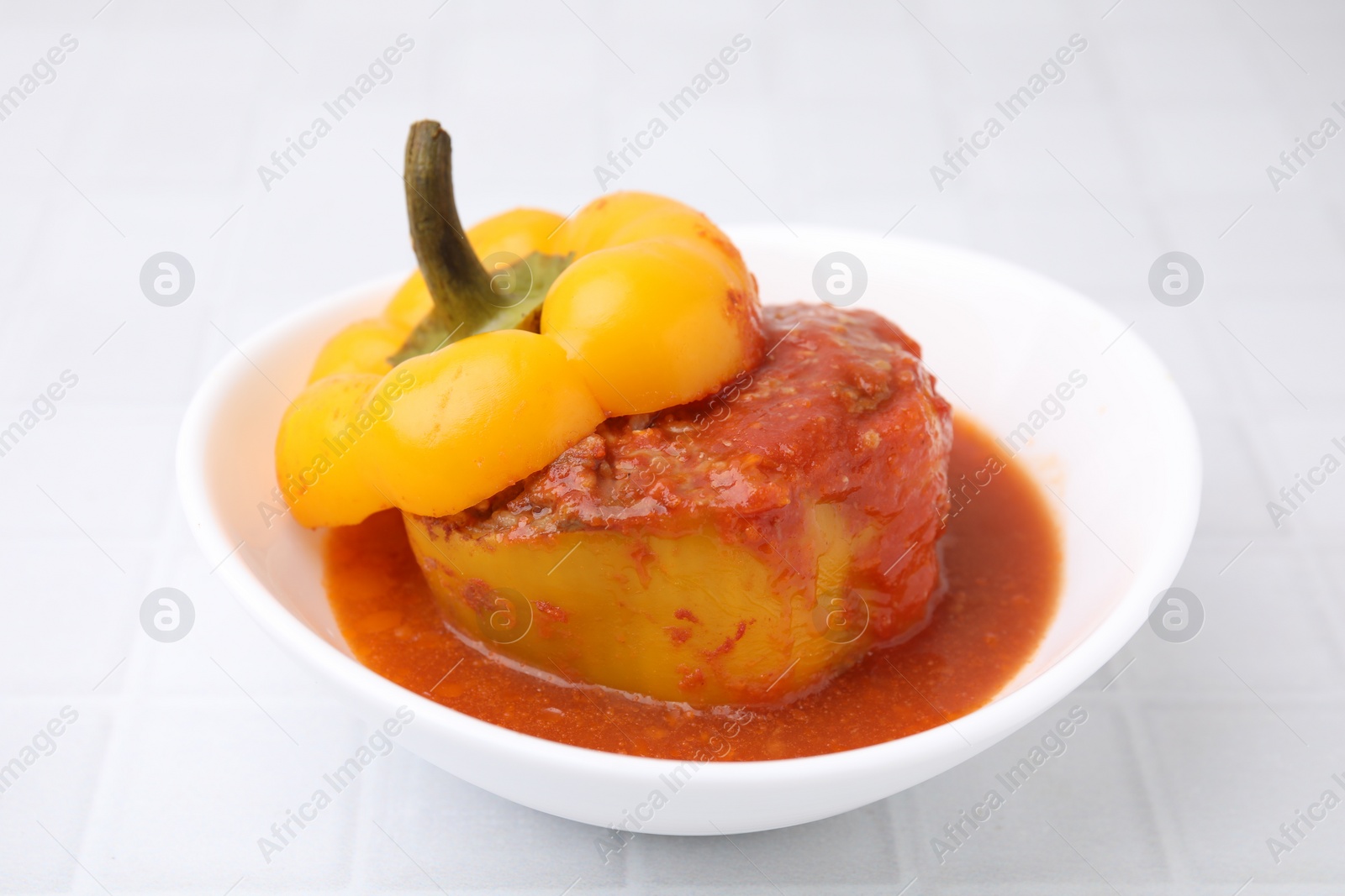 Photo of Delicious stuffed bell peppers on white tiled table