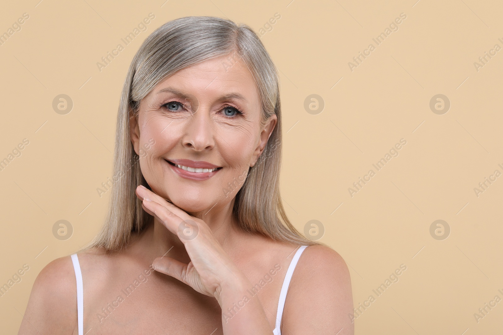 Photo of Portrait of beautiful senior woman on beige background. Space for text