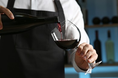 Photo of Bartender pouring wine into glass in restaurant, closeup