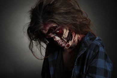 Photo of Scary zombie on dark background. Halloween monster