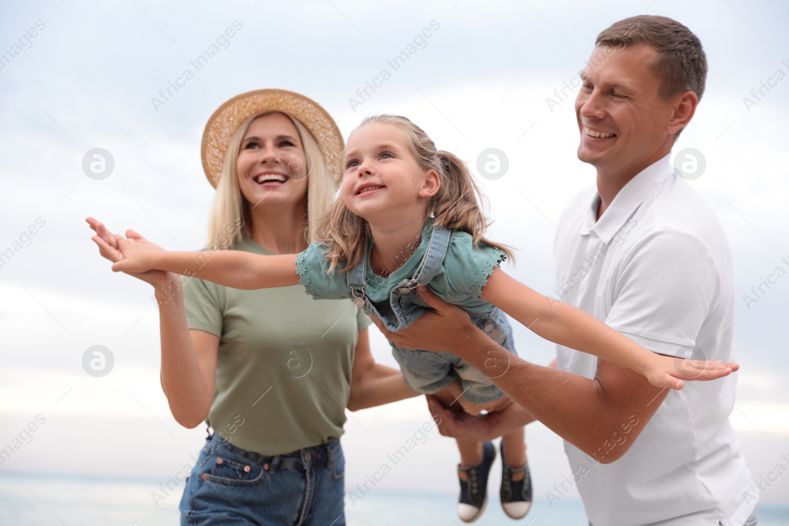 Photo of Happy family spending time together near sea on sunny summer day