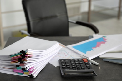 Stack of documents and calculator on office table