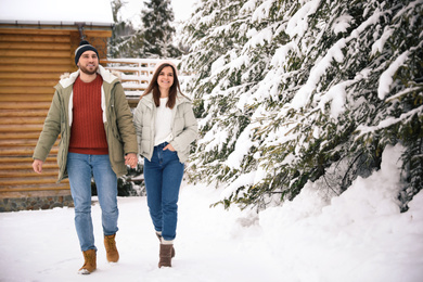 Lovely couple spending time together on snowy day. Winter vacation