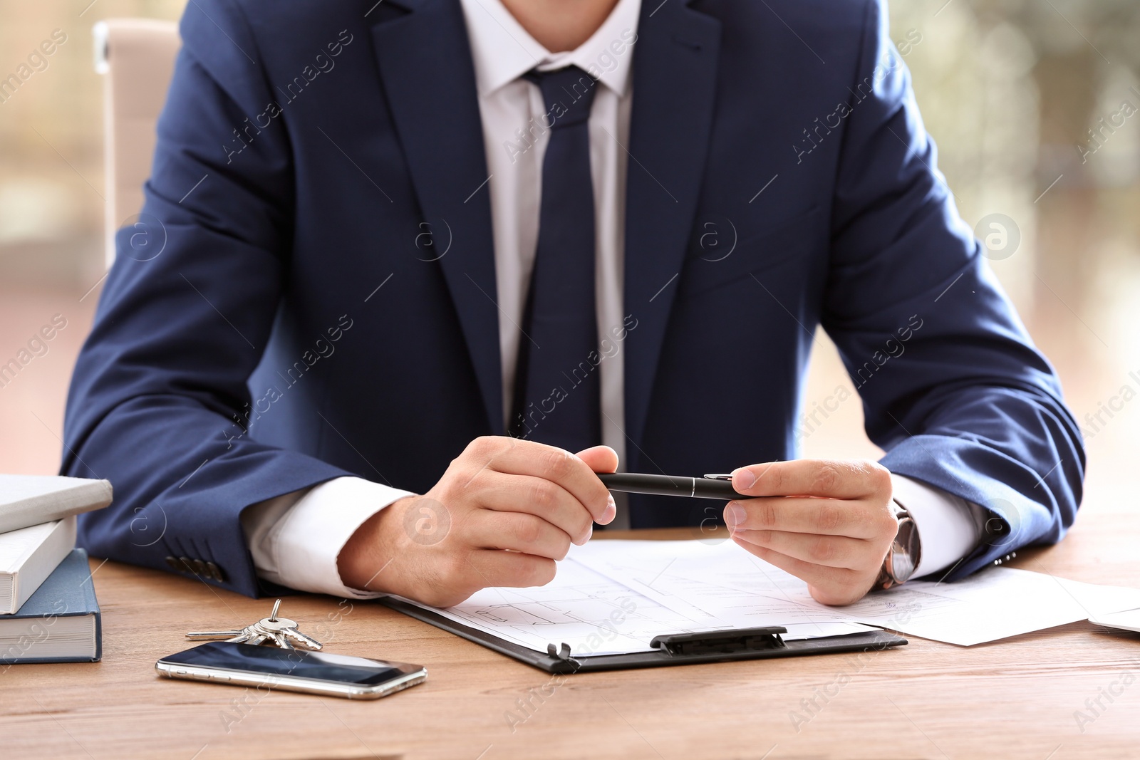 Photo of Real estate agent at table in office, closeup