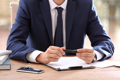 Real estate agent at table in office, closeup