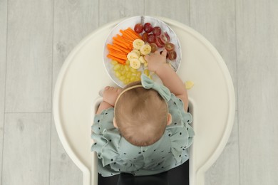 Cute little girl eating healthy food, top view