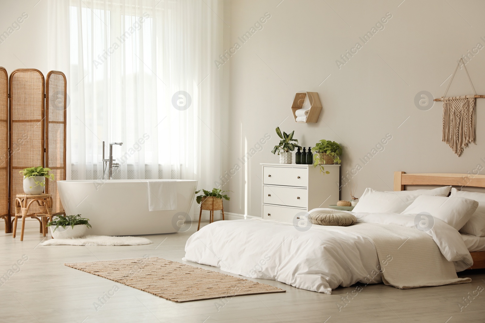Photo of Stylish apartment interior with white bathtub and bed