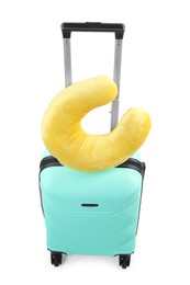 Photo of Soft travel pillow on turquoise suitcase isolated on white