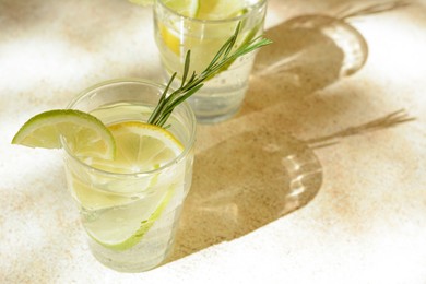 Photo of Glasses of tasty refreshing lemonade on light table, space for text. Summer drink