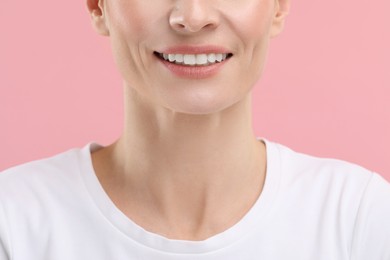 Photo of Woman with clean teeth smiling on pink background, closeup