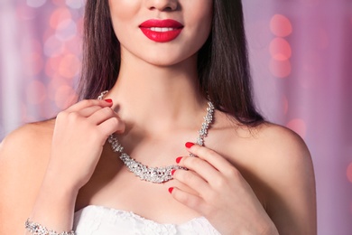 Photo of Beautiful woman with stylish jewelry against blurred lights, closeup