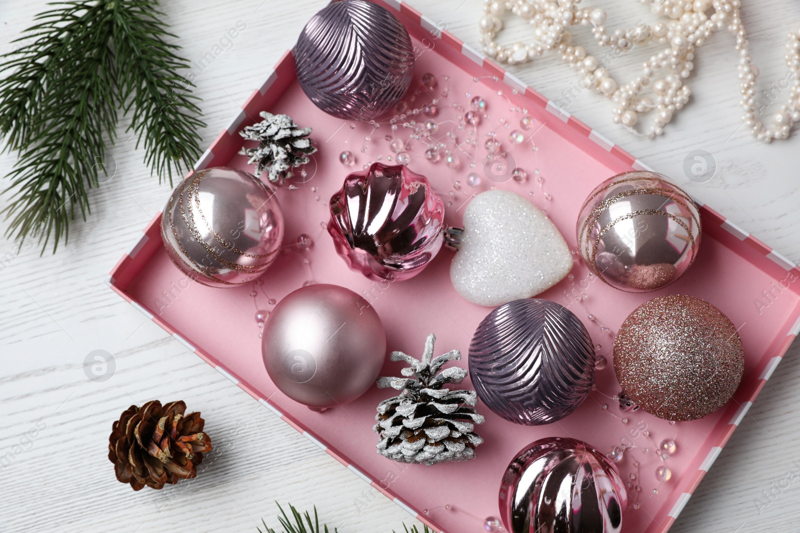 Photo of Flat lay composition with beautiful Christmas baubles on white wooden table