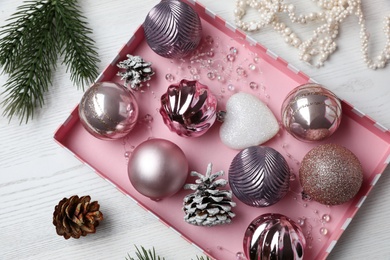 Photo of Flat lay composition with beautiful Christmas baubles on white wooden table