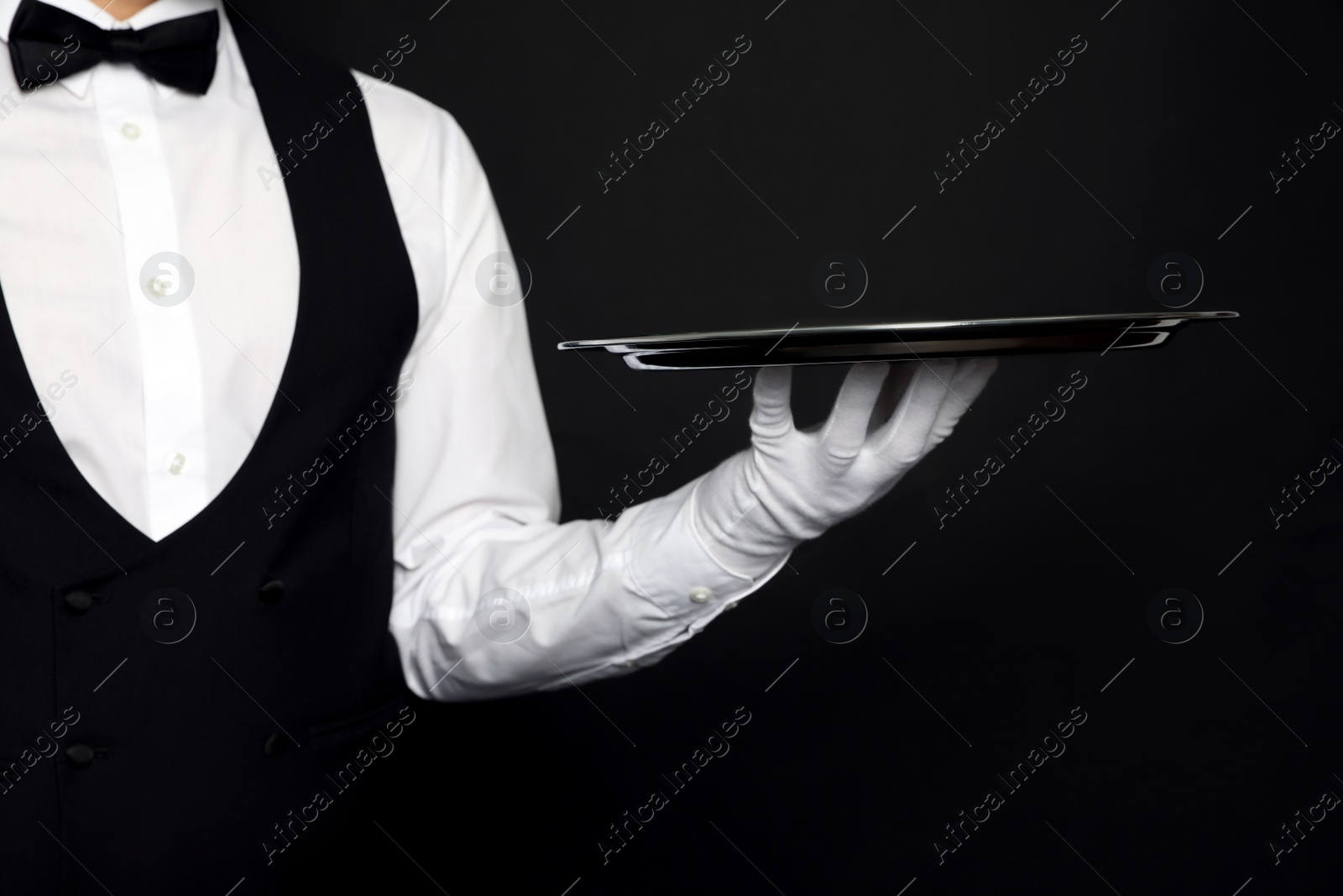 Photo of Butler with tray on black background, closeup