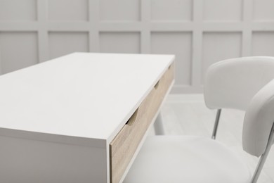 Photo of Modern white table with office chair indoors, closeup