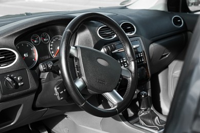 Photo of Black steering wheel and dashboard in car