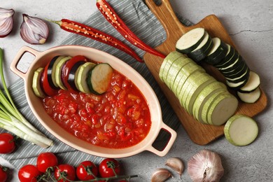 Dressing for ratatouille and different fresh vegetables on light grey table, flat lay