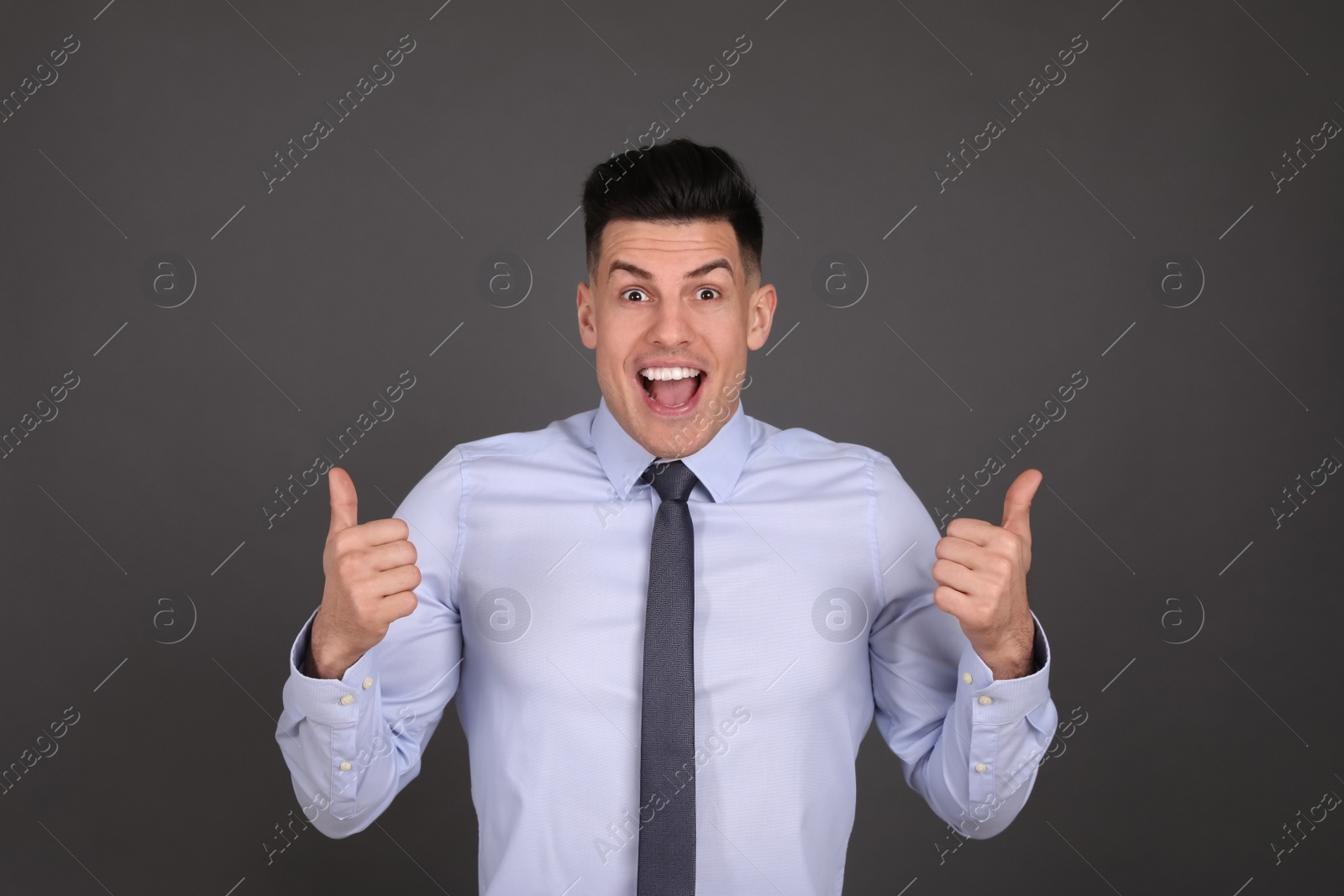 Photo of Portrait of happy businessman on dark grey background. Personality concept