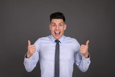 Photo of Portrait of happy businessman on dark grey background. Personality concept