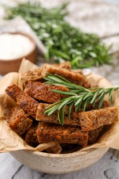 Photo of Crispy rusks with rosemary on white table, above view