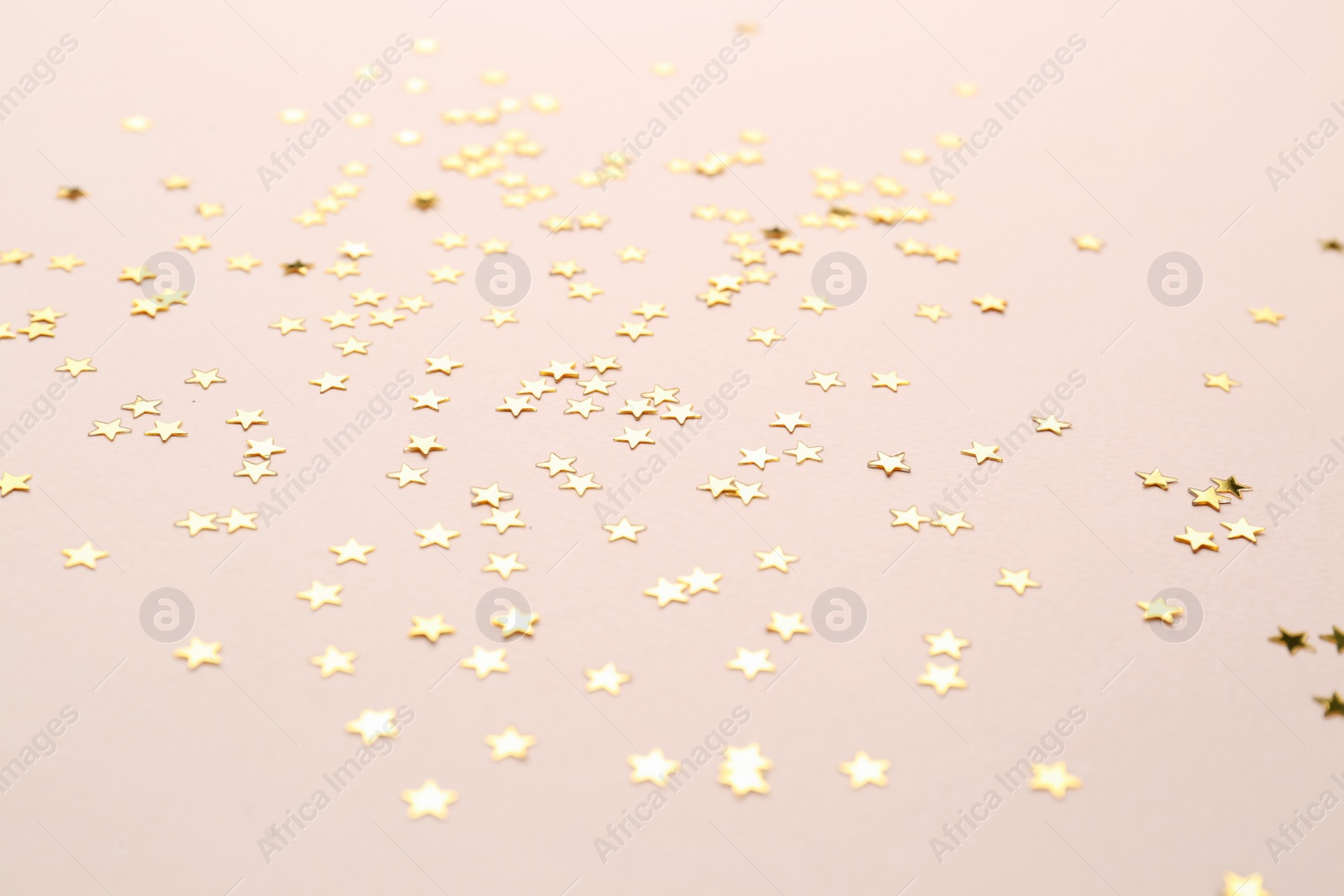 Photo of Confetti stars on pink background. Christmas celebration
