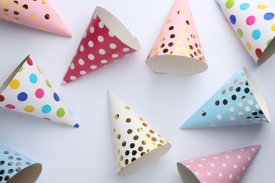 Photo of Colorful party hats on light background, top view