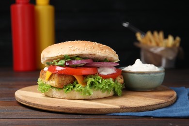 Delicious tofu burger served with sauce on wooden table
