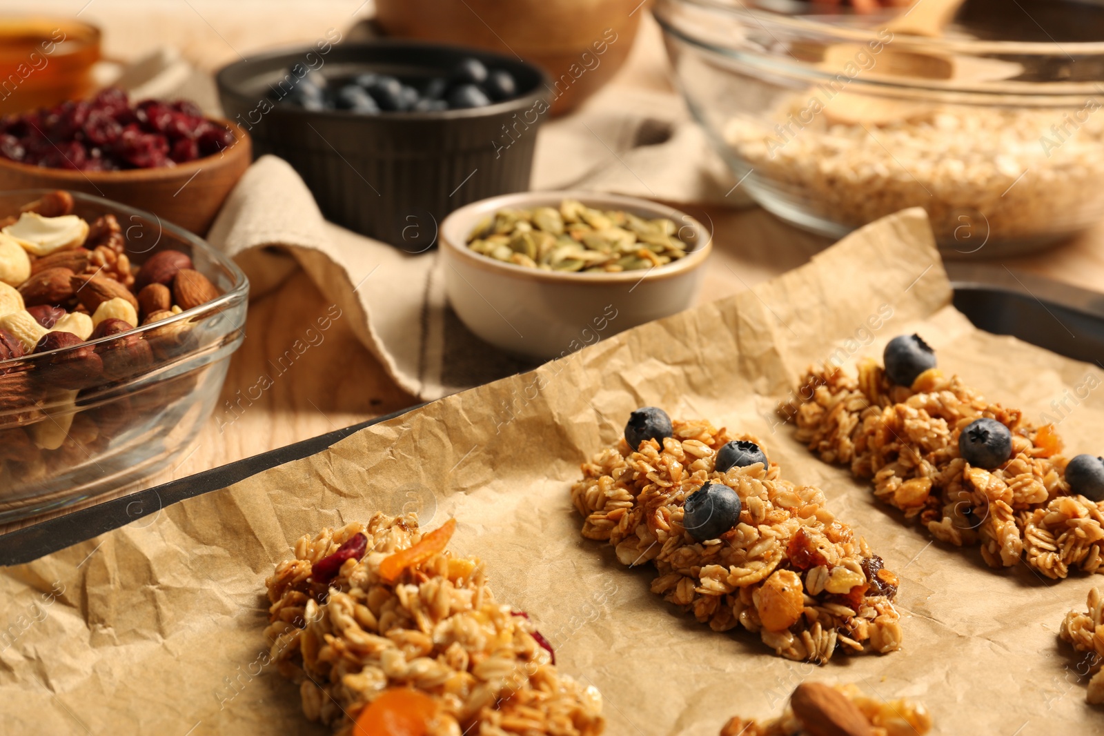 Photo of Different granola bars and ingredients on table, selective focus. Healthy snack