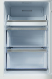 Photo of Shelves of empty modern refrigerator, closeup view