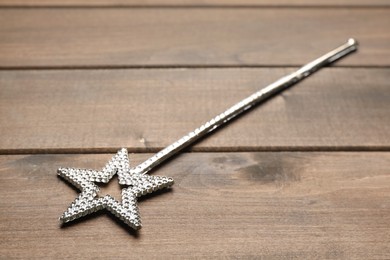 Photo of Beautiful silver magic wand on wooden table