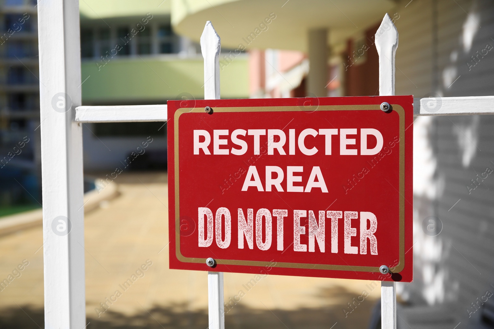 Image of Sign with text Restricted Area Do Not Enter on fence outdoors