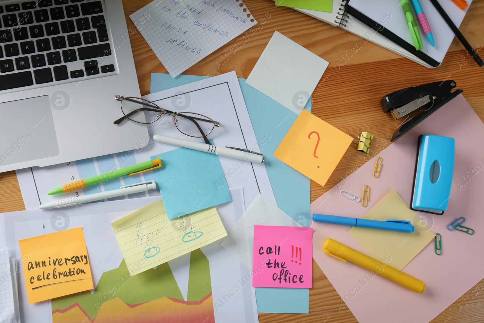 Photo of Messy table with laptop and sticky notes, flat lay. Concept of being overwhelmed by work