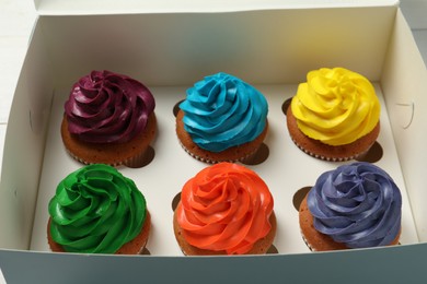 Photo of Different cupcakes with cream in box, closeup