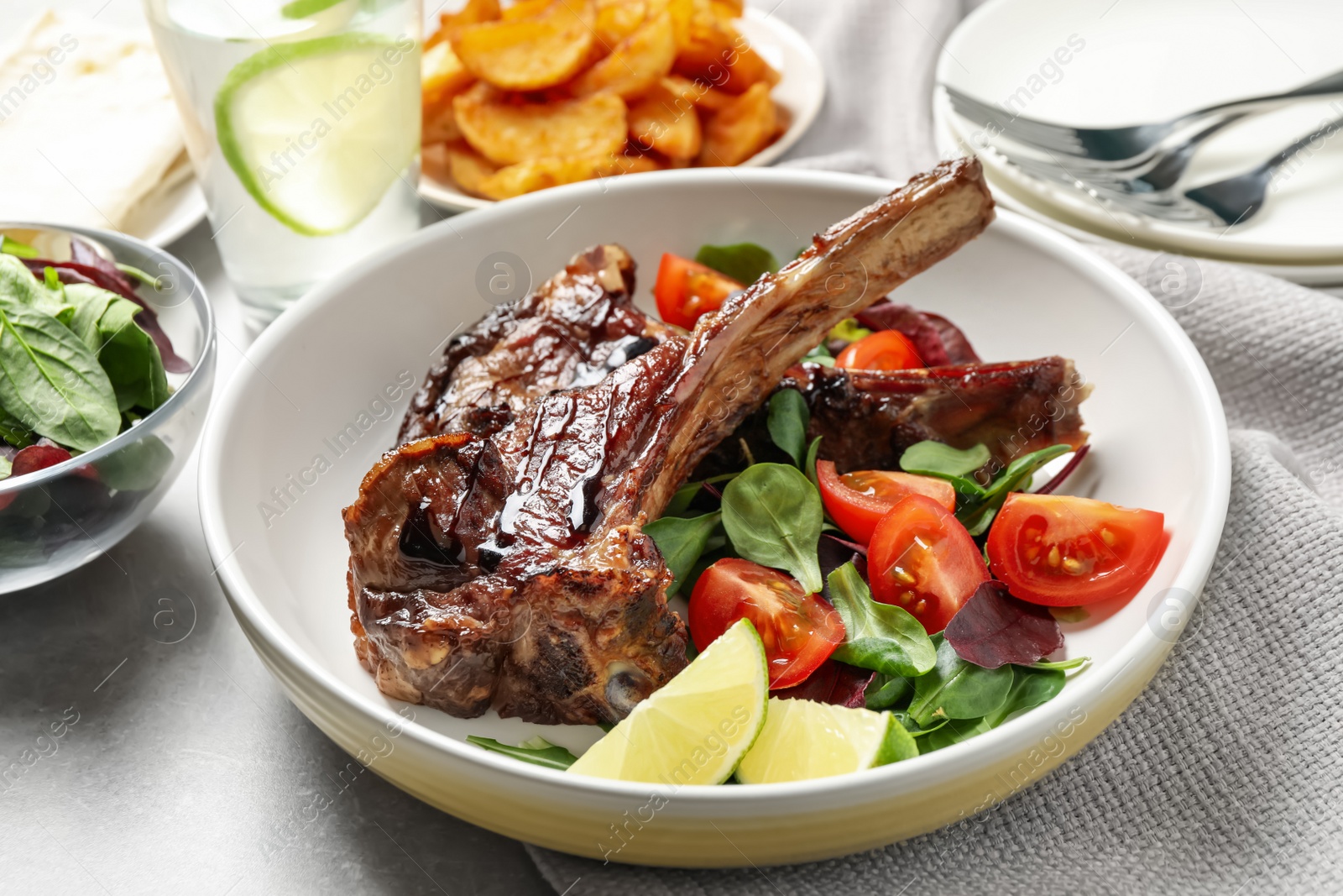 Photo of Delicious grilled ribs served on light grey table