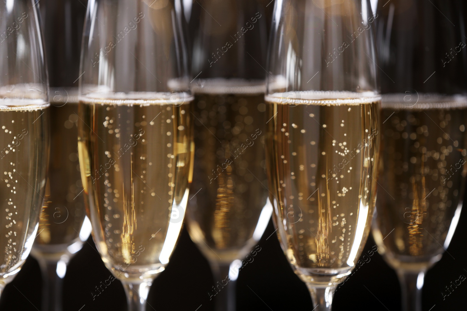 Photo of Glasses of champagne on dark background, closeup