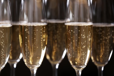 Photo of Glasses of champagne on dark background, closeup