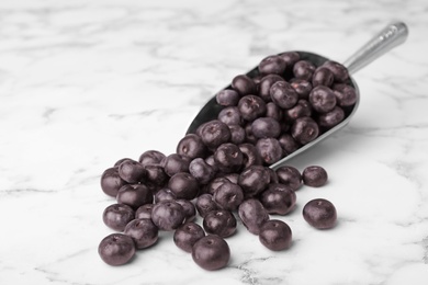 Photo of Metal scoop of fresh acai berries on marble table, space for text